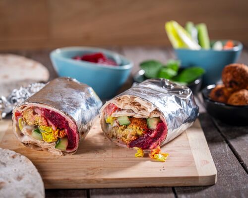 Falafel Wrap vegan Veganer Falafel Wrap halbiert und serviert auf einem Holzbrett – gefüllt mit Hummus, Rote Bete, frischem Gemüse und knusprigen Falafelbällchen.
