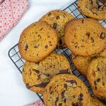 Vegane Chocolate Chip Cookies auf einem Backgitter, goldbraun gebacken, mit großen Schokoladenstücken, perfekt für den veganen Genuss.