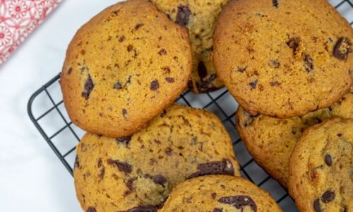 Vegane Chocolate Chip Cookies auf einem Backgitter, goldbraun gebacken, mit großen Schokoladenstücken, perfekt für den veganen Genuss.