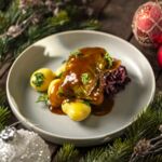 Ein festlich angerichtetes Gericht mit einer veganen Kohlroulade, serviert in einer veganen Bratensoße. Dazu gibt es Petersilienkartoffeln sowie Rotkohl als Beilage. Tannenzweige und Weihnachtskugeln im Hintergrund.