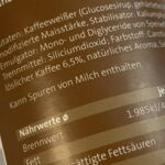 Nahaufnahme eines veganen Produkts mit Zutatenliste, darunter Kaffeweißer, Maistärke und Hinweise auf Spuren von Milch. Ideal für bewusste Veganer!