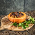 Gefüllter Kürbis vegan: Hokkaido aus dem Ofen mit pflanzlicher Hackfüllung und Kräutern, serviert als herbstliches Hauptgericht.