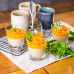 Veganer Vanillepudding im Glas mit Mango-Aprikosen-Topping und frischer Minze, cremiges Dessert ohne Milch und Ei.