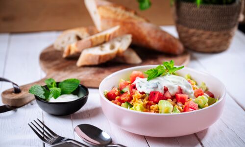 Linsensalat vegan Frischer Linsensalat vegan mit roten Linsen, knackiger Wassermelone, Gurke und Minzsauce in einer rosa Schüssel, serviert mit frischem Baguette – ein sommerliches Linsensalat Rezept ohne tierische Produkte.