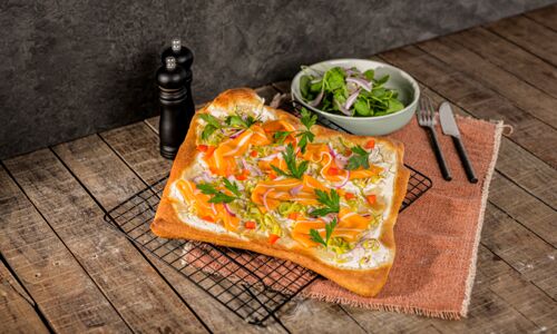 Veganer Flammkuchen mit Laxx, Porree, roten Zwiebeln, Paprika und Petersilie, dazu ein frischer Babyspinat-Salat.
