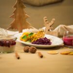 Traditionelles veganes Weihnachtsessen mit veganem Braten, Rotkohl und Kartoffeln, serviert in weihnachtlicher Atmosphäre auf einem festlich gedeckten Tisch.