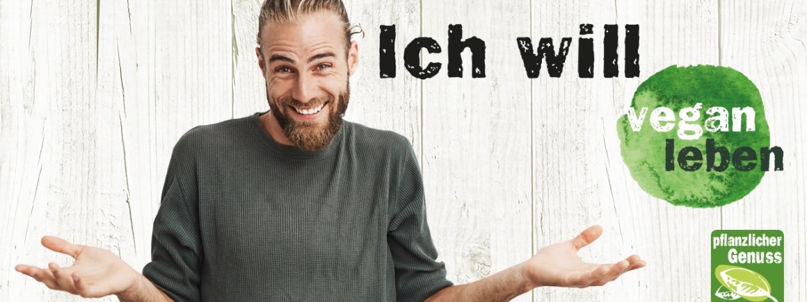 Ein Mann mit Bart lächelt und hebt fragend die Hände, daneben der Schriftzug "Ich will vegan leben" auf einem weißen Holzhintergrund.