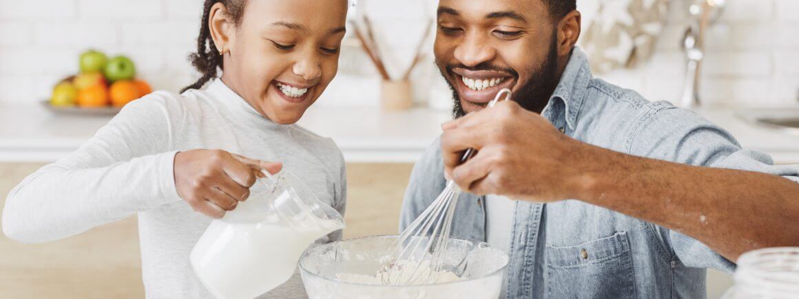 Ein Vater und Kind backen gemeinsam in der Küche mit veganer Milchalternative – perfekte Wahl fürs vegane Backen!